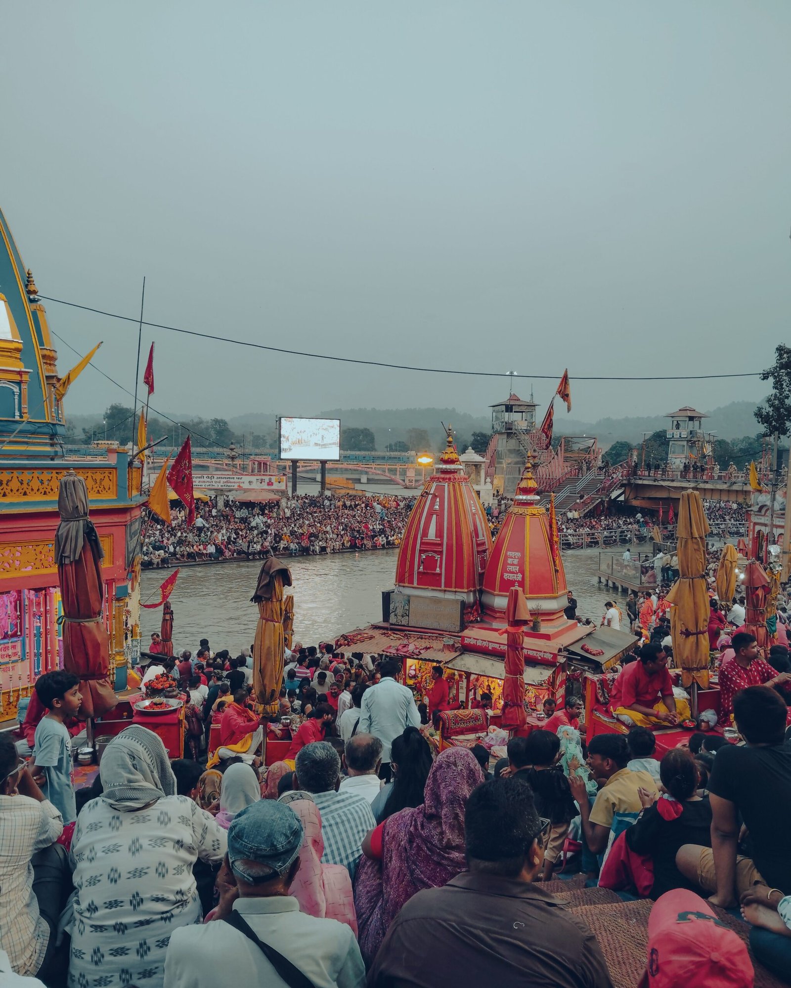 A bustling scene at Haridwar with devotees by the Ganges, showcasing cultural richness and spiritual activities.